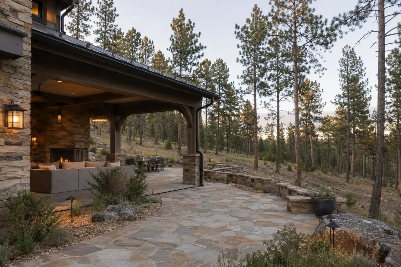 Illustrative wildfire-aware Evergreen estate with a stone terrace, covered room, and defensible-space planting